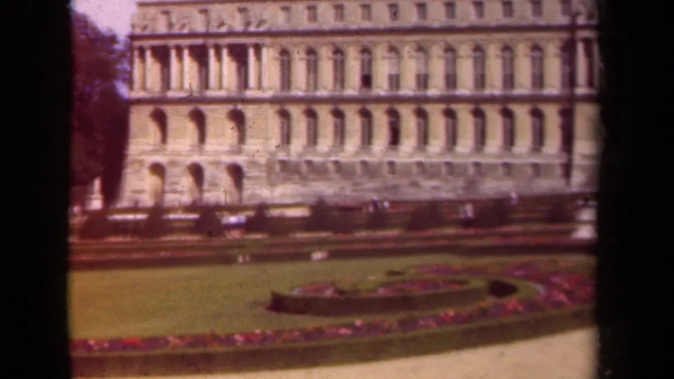 1939 Paris home-movie view of formal lawns, magenta flowerbeds, and an ornate palace-like facade.
