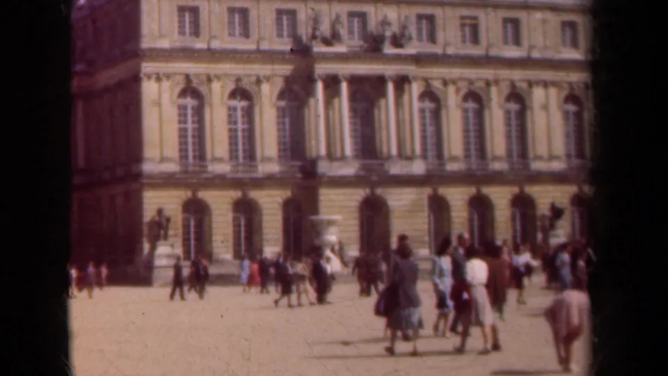 1939 Paris courtyard scene with visitors in period dress moving before a classical palace facade with arched windows.