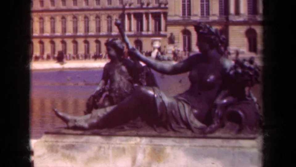 Final 1939 home-movie frame of the reclining statue group at the reflecting pool, with palace architecture and visible film borders.