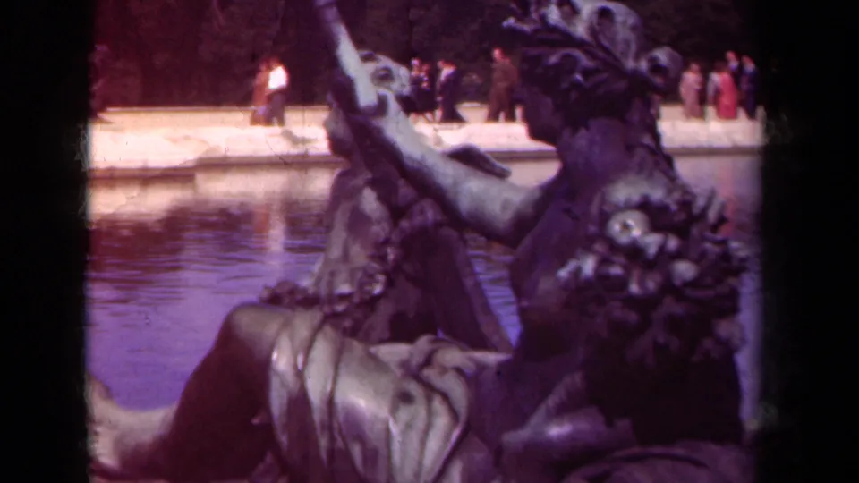 1939 Paris-area home-movie view of bronze garden sculpture near water, with small groups of visitors beyond the pool.