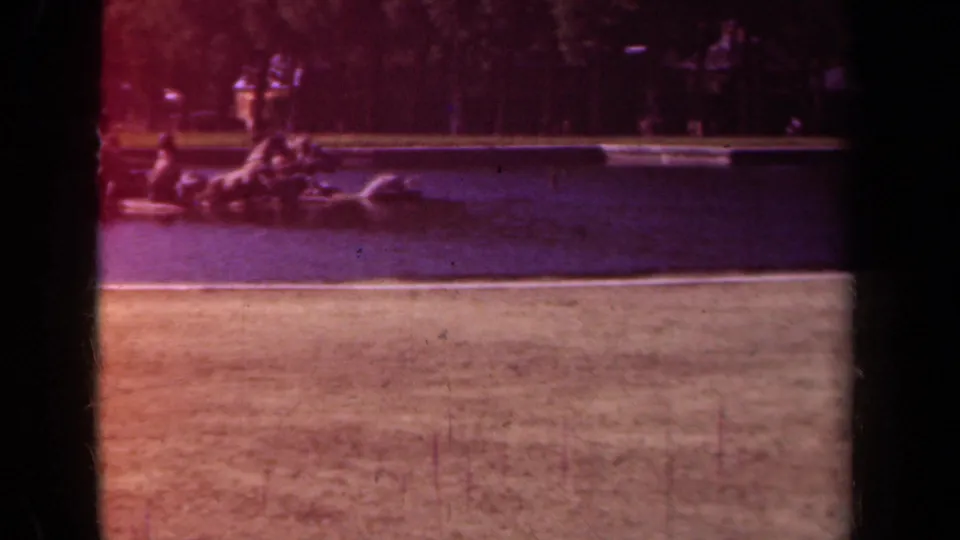 1939 Paris park footage shows a distant sculpture or fountain near a water basin, with lawn, trees, and soft reddish color shift.