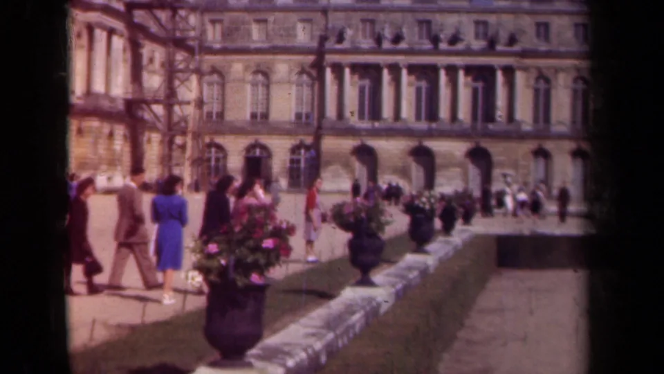 Paris, 1939 footage shows visitors walking and gathering near large flower pots in a palace courtyard with scaffolding at one side.