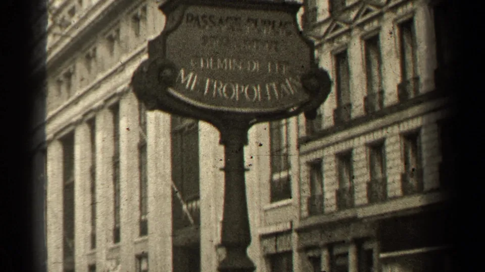 1947 Paris street view with an ornate Passage Petits-Pères and Métropolitain sign, stone facades, and distant pedestrians.