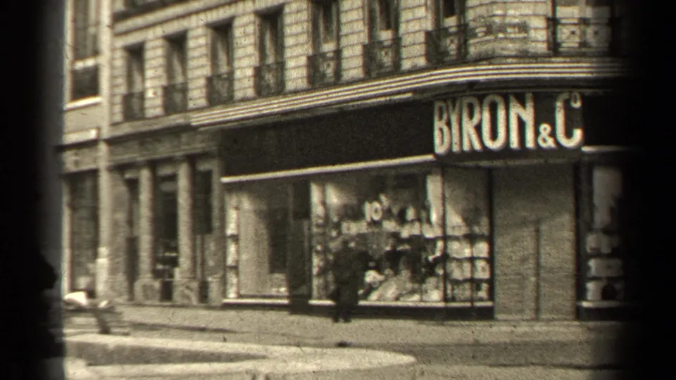 1947 Paris street view showing the Byron & C storefront, stone building facade, large windows, and a lone pedestrian near the corner.