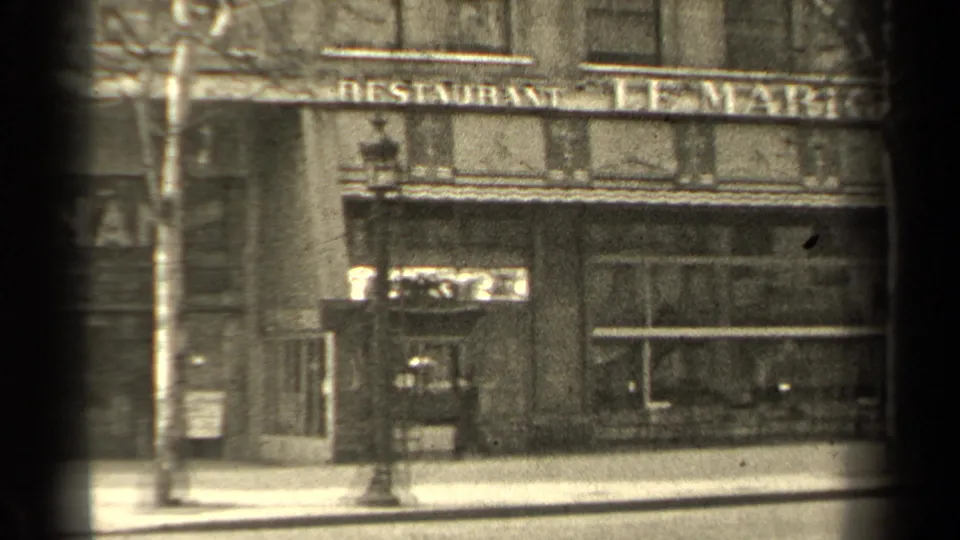 1947 Paris street view of the Le Marignan restaurant frontage with bare trees, windows, and sidewalk seen through 8mm film framing.