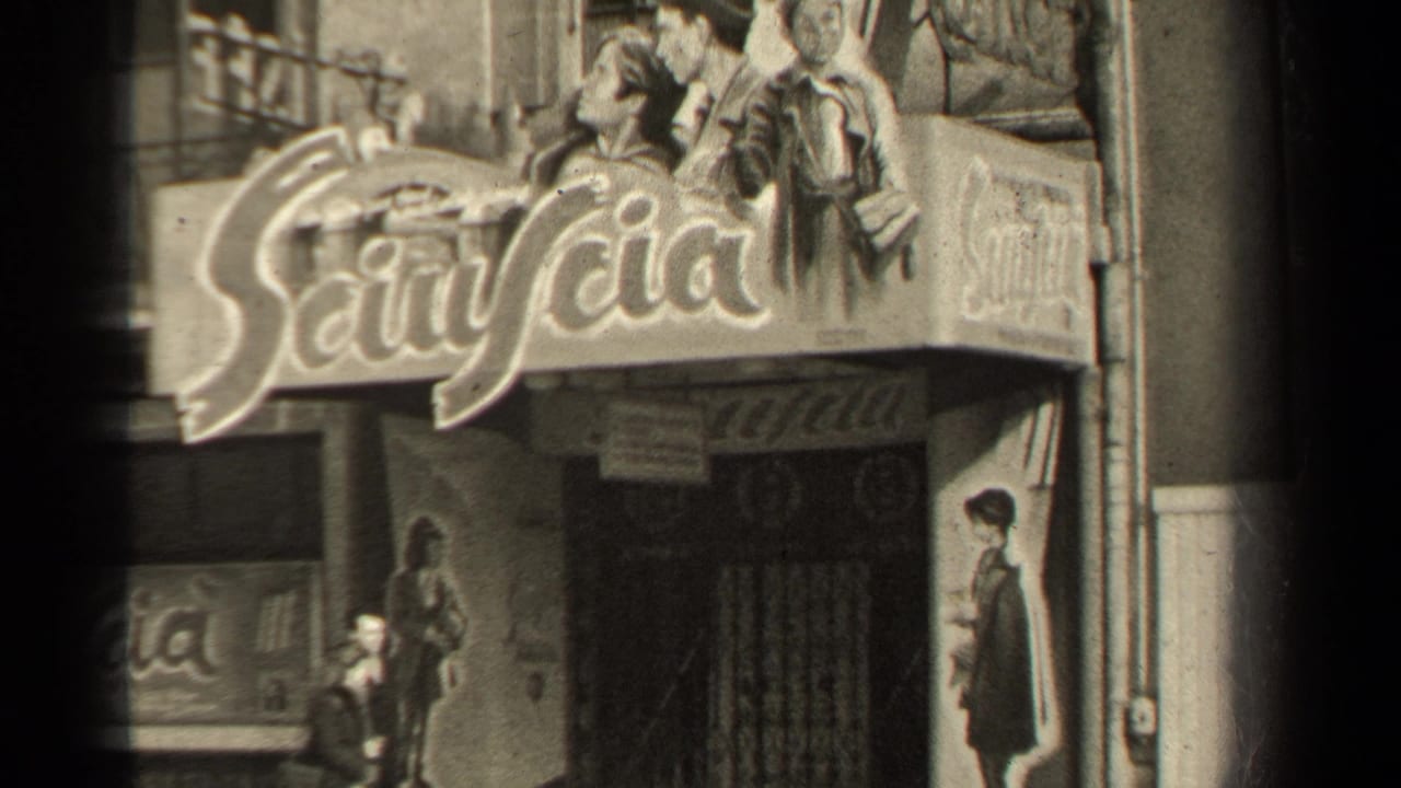 Paris theater frontage with large signage and pedestrians passing below.