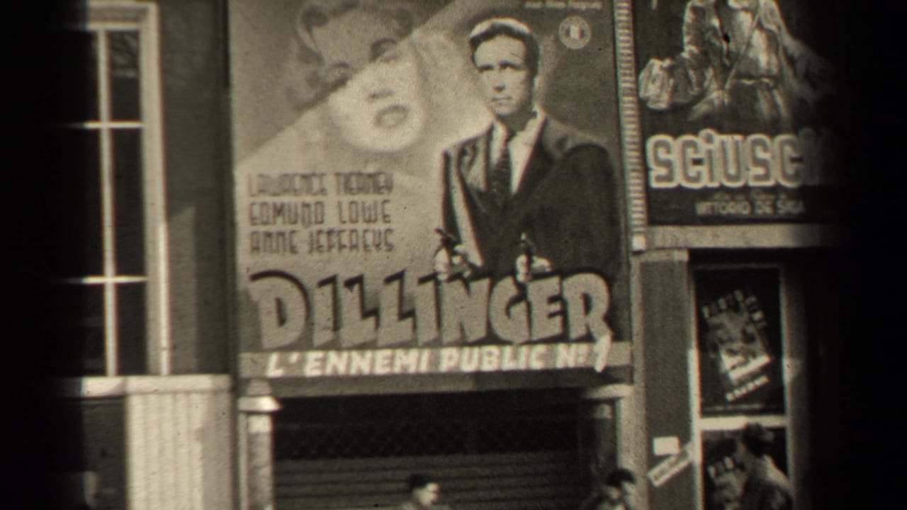 Large Dillinger poster beside another film poster and theater windows.