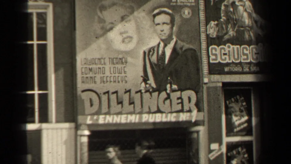 1947 Paris street frame centered on a Dillinger poster with cast names, adjacent signage and pedestrians at the bottom.