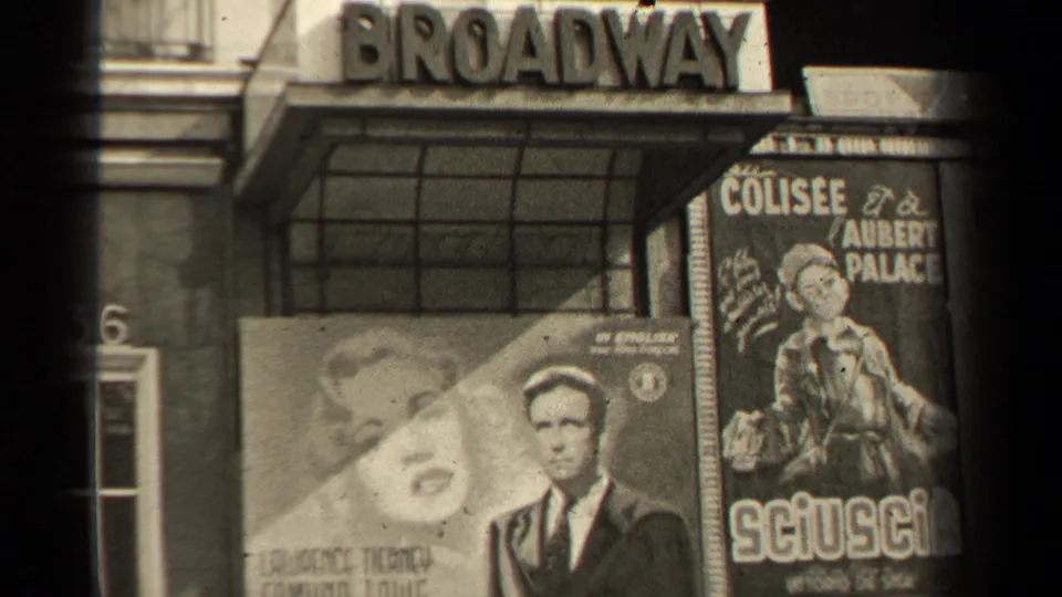 Paris theater exterior with a Broadway marquee and French movie posters visible in grainy 1940s 8mm footage.