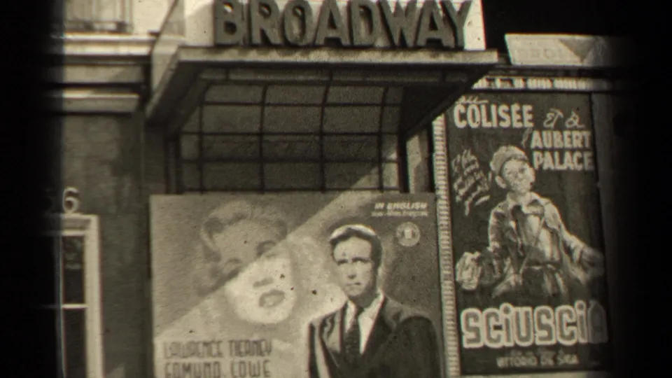 Close view of a Paris cinema facade showing the Broadway sign, poster artwork, and French advertising text.