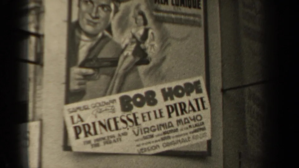 Final 1947 Paris frame on the wall-mounted La Princesse et le Pirate poster, with the poster angled across the shot.