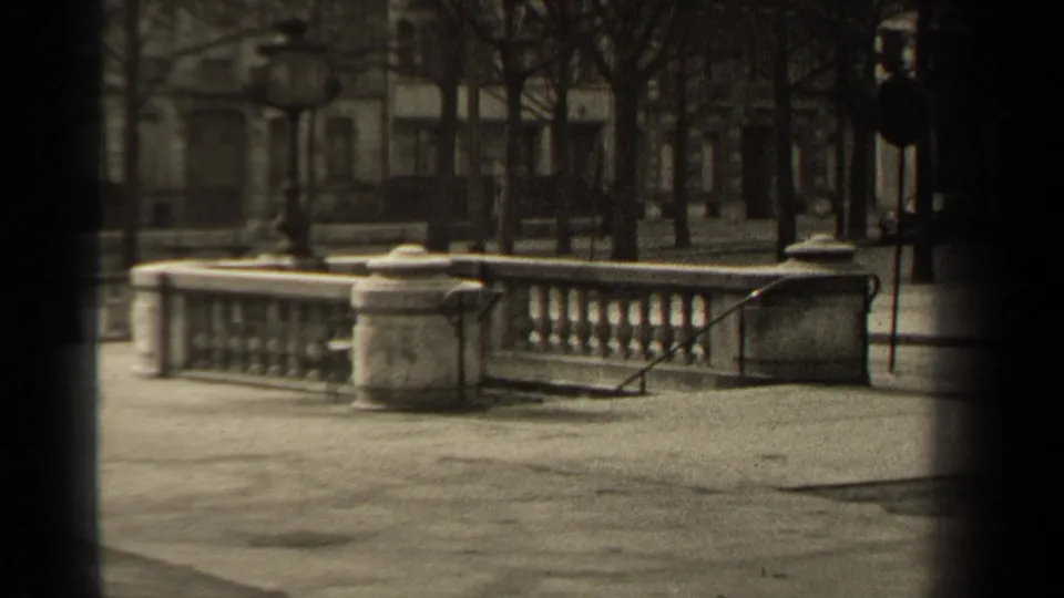 1947 Paris street-side view showing a stone balustrade, steps, bare trees, a signpost, and distant building facades.