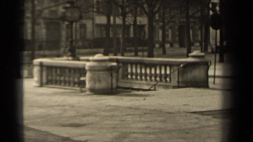 1947 Paris street view showing a stone balustrade, bare trees, lampposts, and soft-focus architecture in the background.