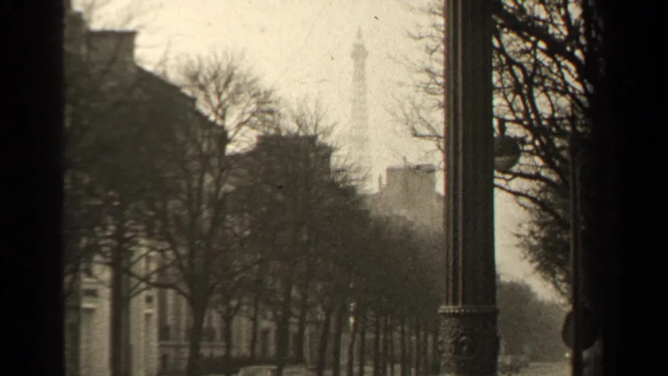 A 1947 Paris view shows the Eiffel Tower in the distance beyond bare trees, a building facade, and a tall street lamp.