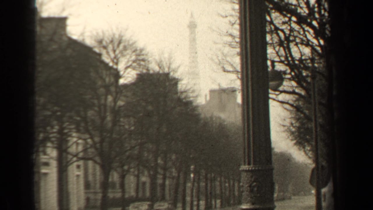 Paris, France street scene from 1947 showing the Eiffel Tower in the distance, framed by bare trees and a lamppost.
