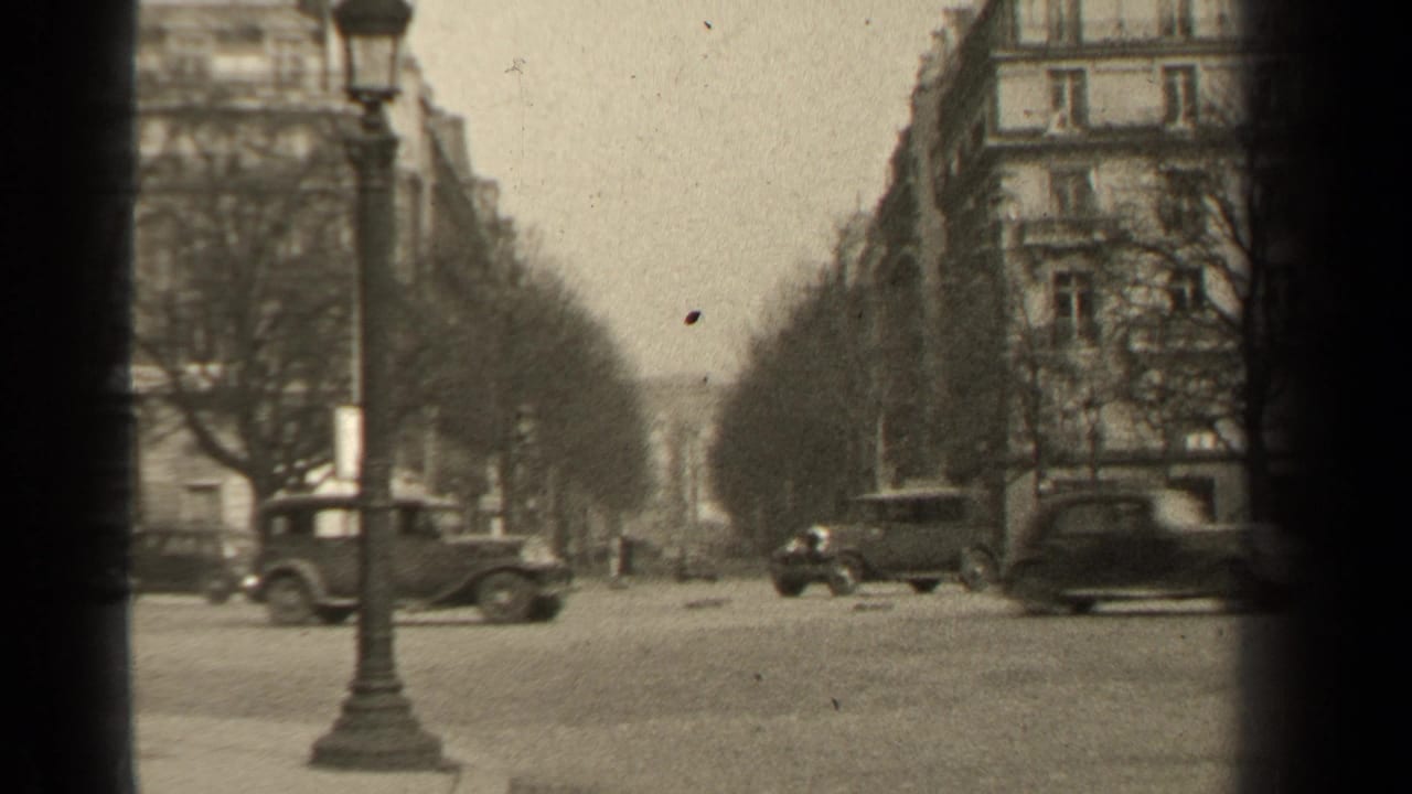 1947 Paris intersection with multiple classic cars, a foreground lamppost, bare trees, and Haussmann-style building facades.