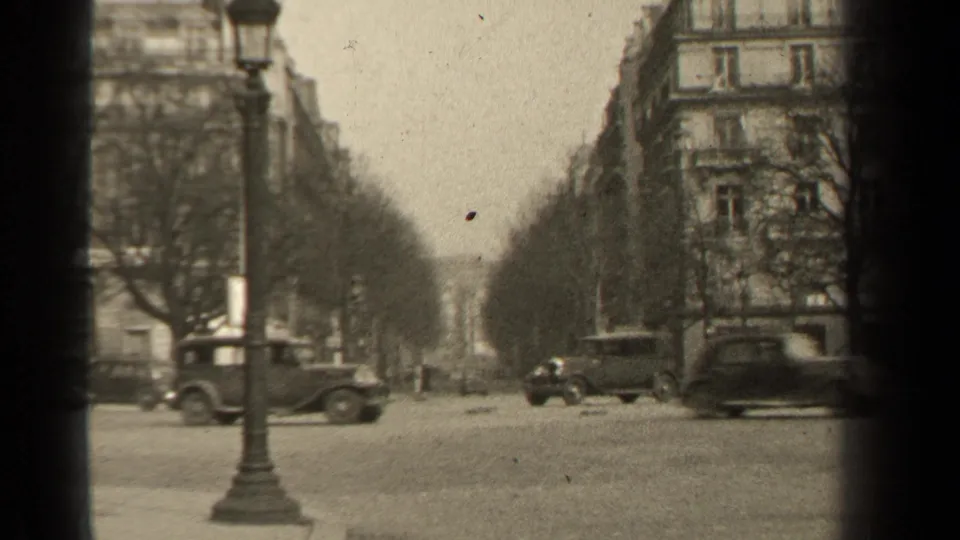 1947 Paris intersection with multiple classic cars, a foreground lamppost, bare trees, and Haussmann-style building facades.