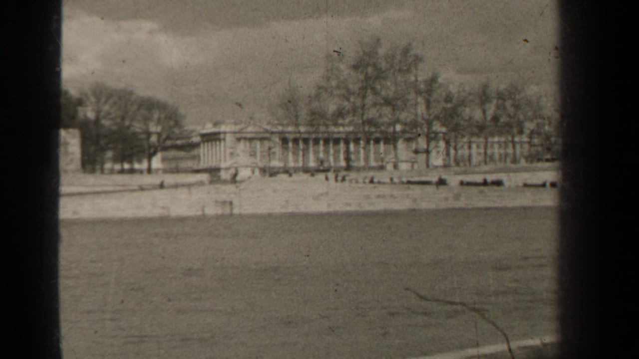 Classical building and bare trees across a broad stretch of water.