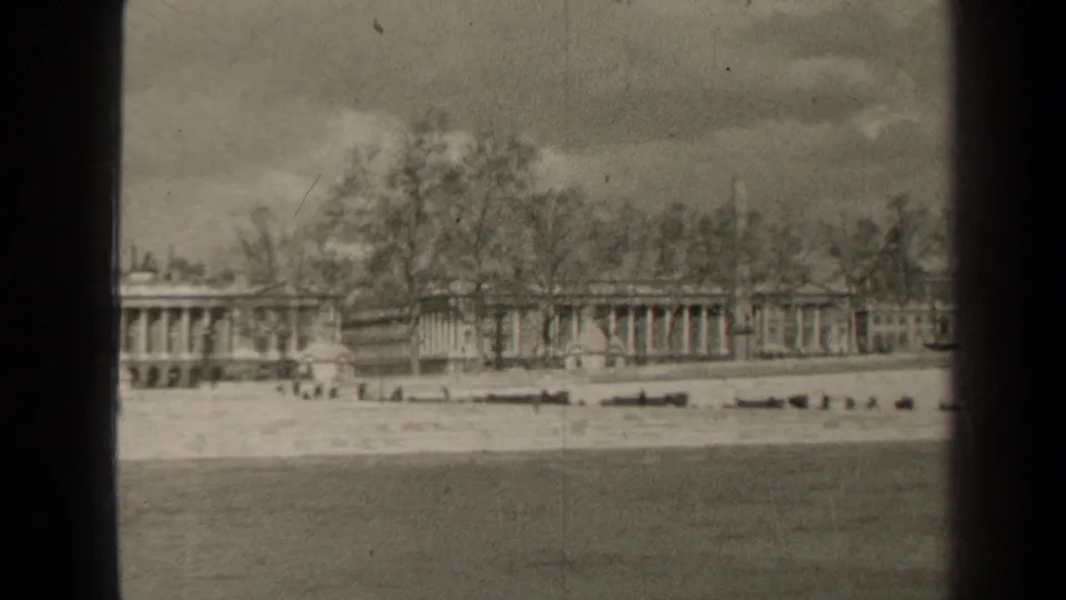 Final 1947 Paris frame holds on the same waterside architecture, with distant people and dark 8mm frame borders visible.