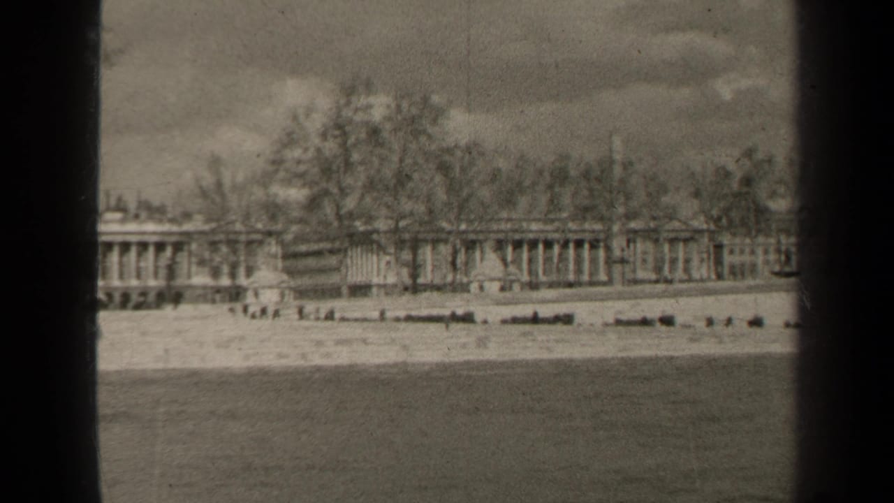 1947 Paris home-movie still showing a soft distant view of formal architecture behind bare trees, seen across water.