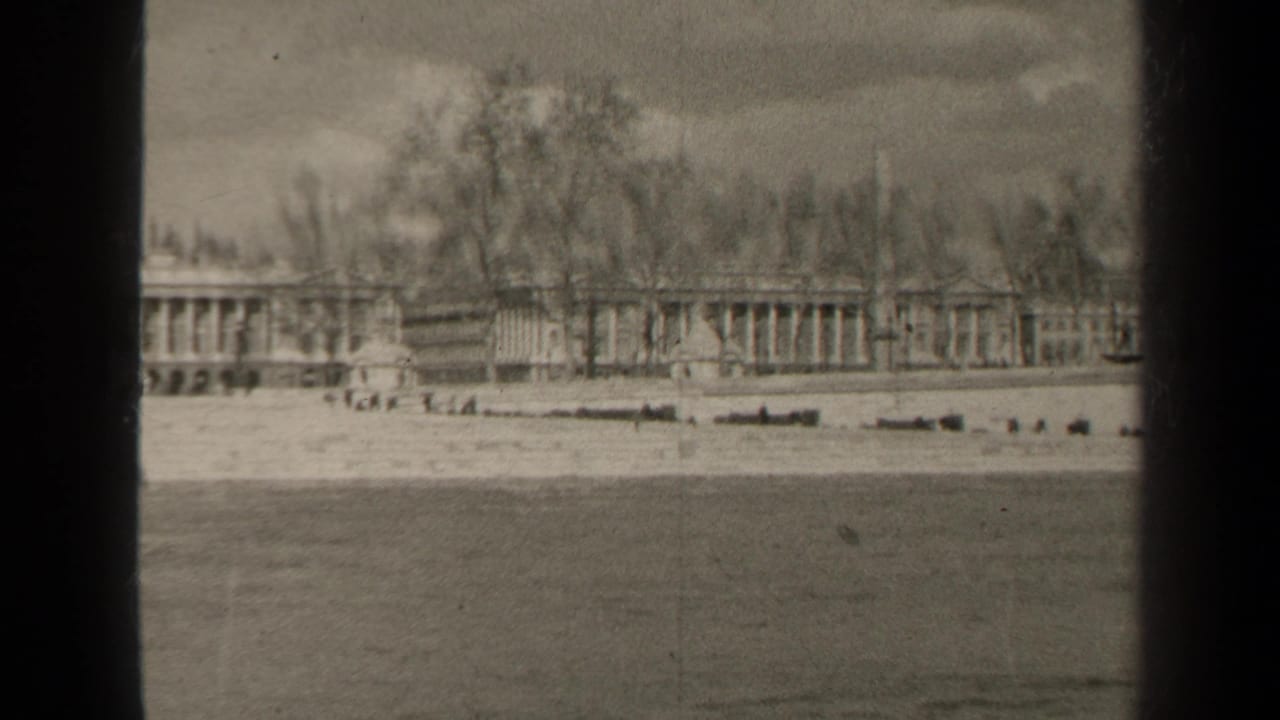 Riverside building and trees viewed across the Seine in a soft black-and-white frame.