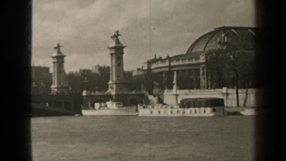 1947 Paris view across the Seine toward Pont Alexandre III, a domed riverside building, and a small boat near the embankment.