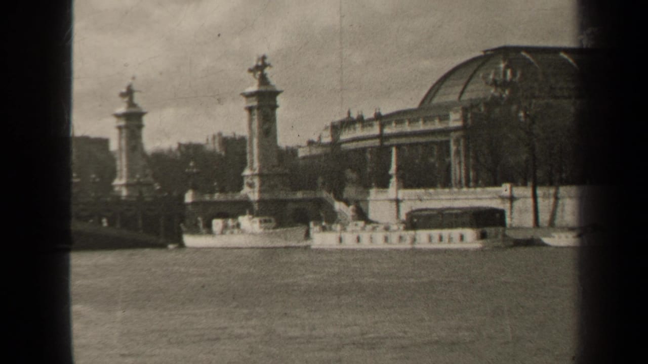 Bridge pillars and statues beside a domed Paris riverside building and boat.