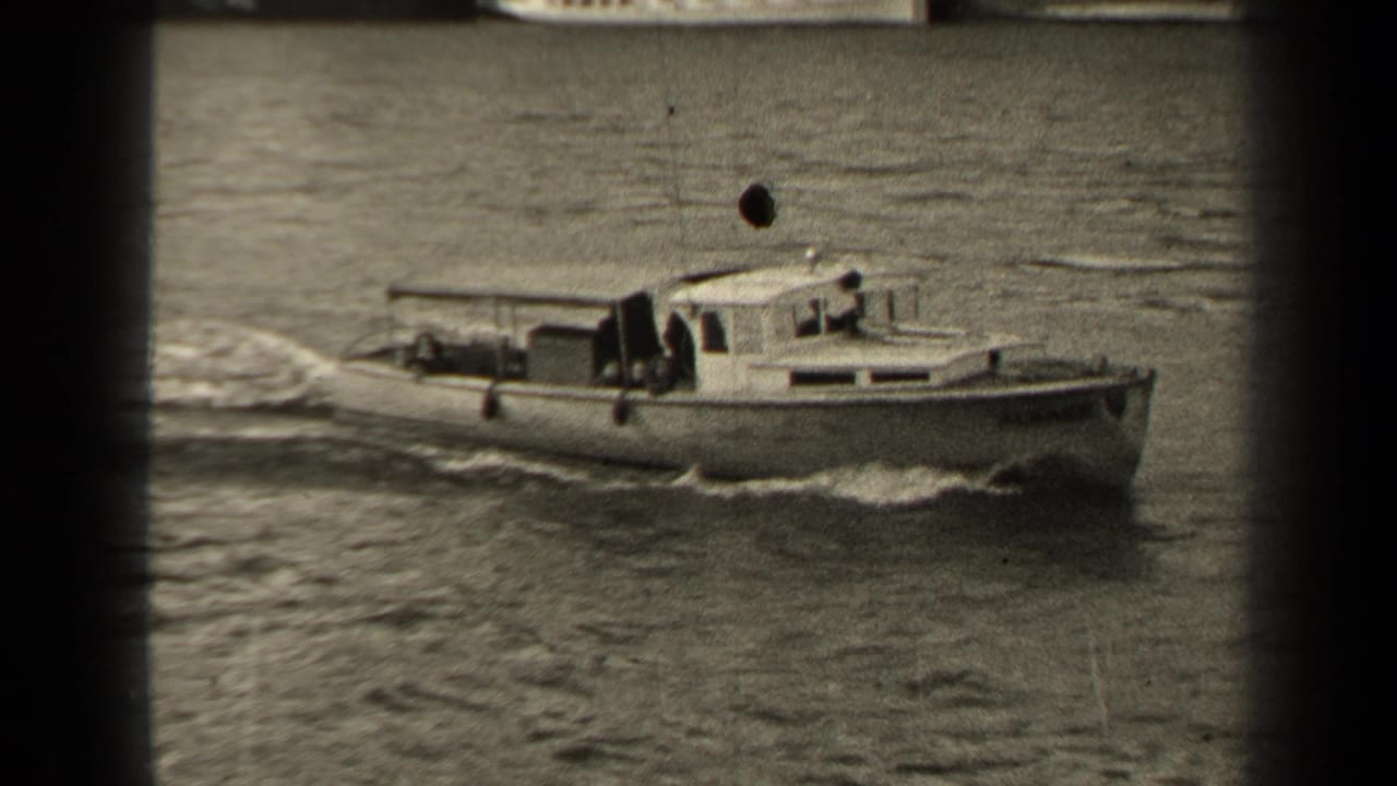 1947 Paris home-movie frame of a small cabin boat traveling along the river, with wake, soft focus, and visible film wear.
