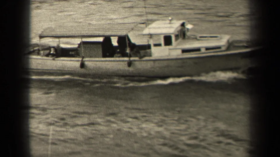 A closer side view shows the small motorboat moving past the camera, with a person near the bow area and the cabin visible against rippled water.