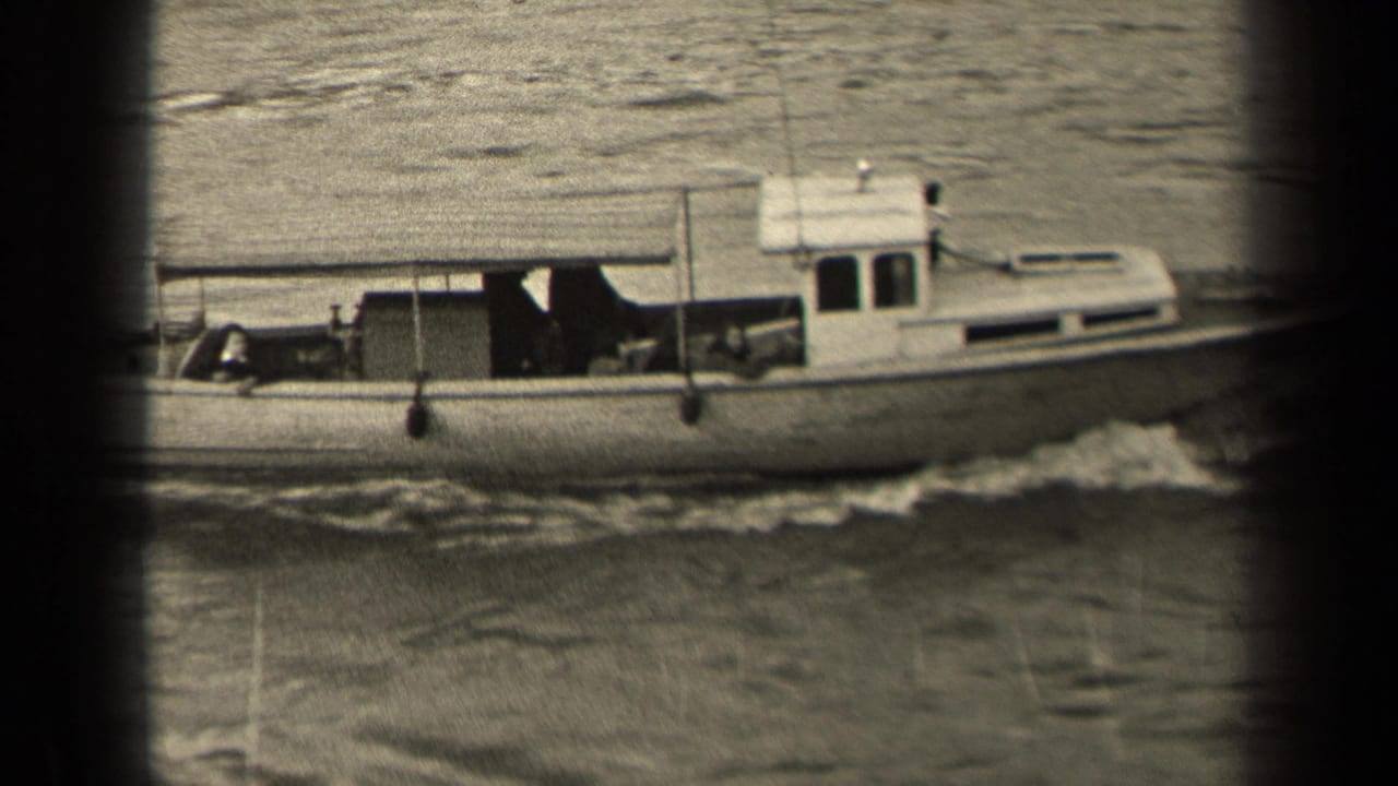 A black-and-white 1947 Paris home-movie frame shows a small motorboat passing across the river with a low wake behind it.