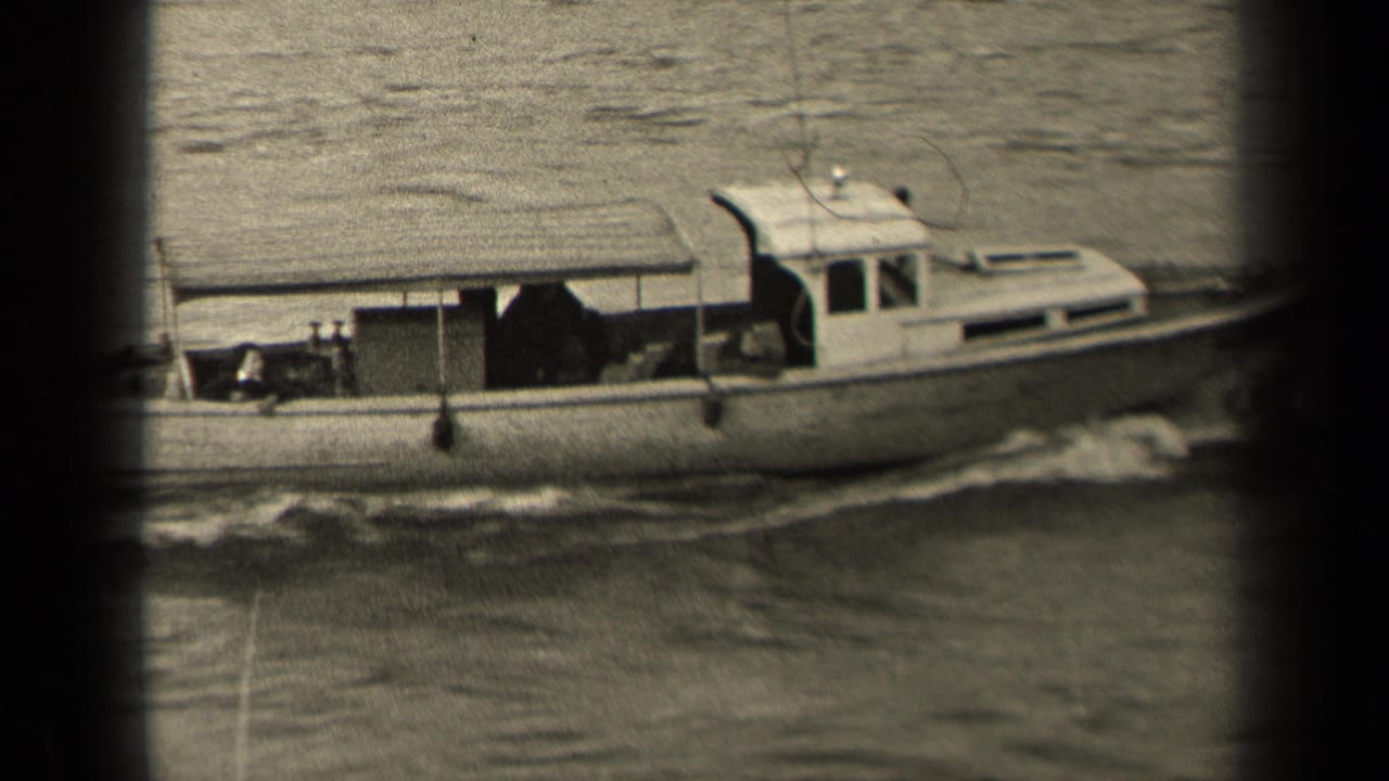 Motorboat continues along the water with its cabin, deck, and wake visible.