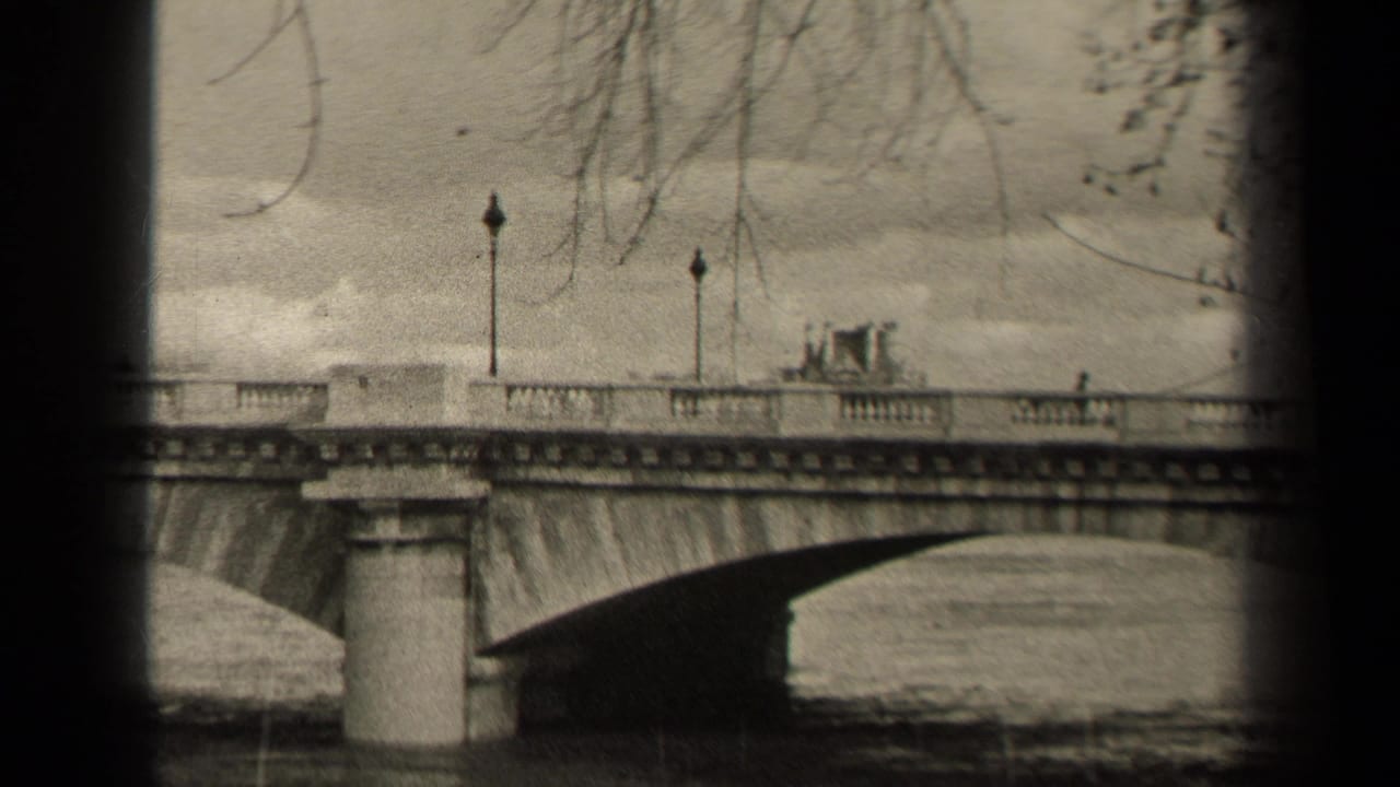 A 1947 Paris home-movie frame shows a stone bridge crossing the river, with lampposts, railings, bare branches, and small distant pedestrians.