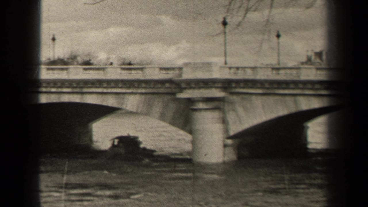 1947 Paris 8mm frame showing the bridge arch, water below, vertical pier, lampposts, and a dark small boat-like form near the bridge.