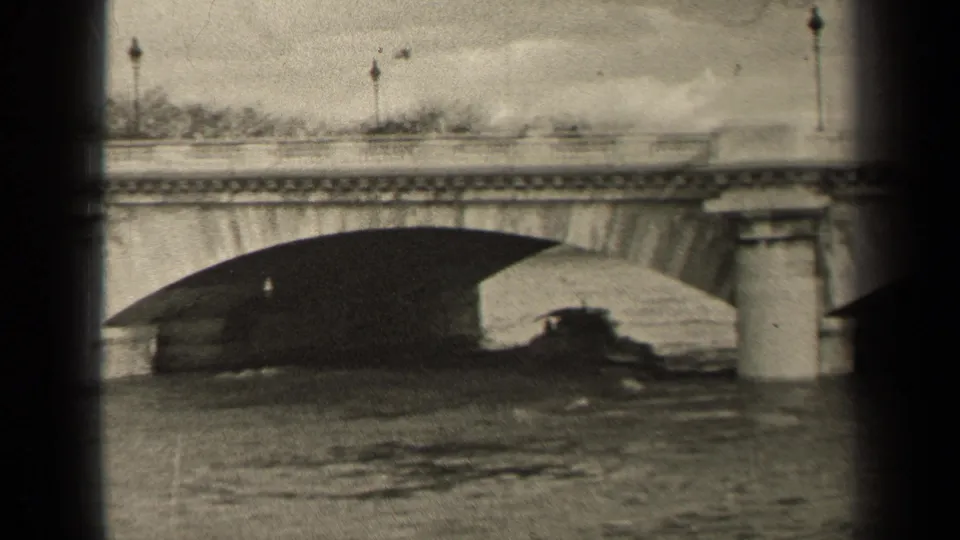 1947 Paris frame of a stone bridge and calm water, with a dark boat-like form under the arch and small pedestrians or traffic on the deck.