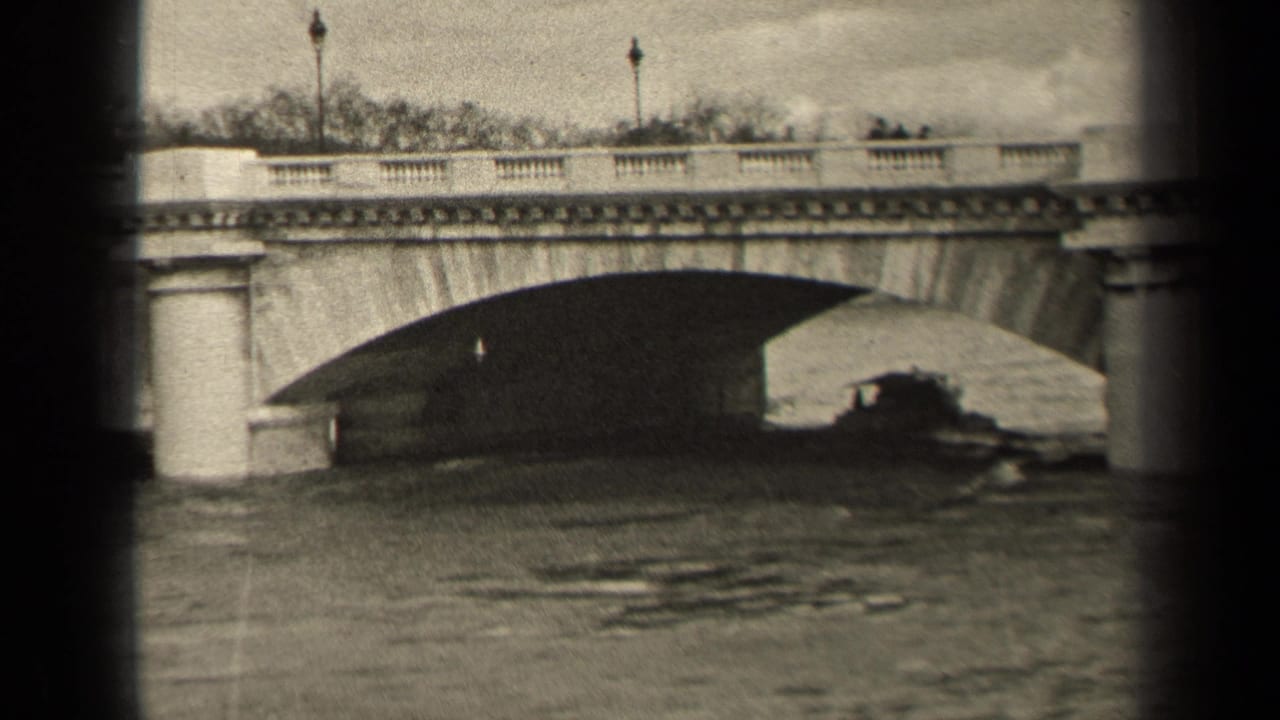 1947 Paris home-movie frame showing a stone bridge, river water, lampposts, and a small boat moving under the arch.