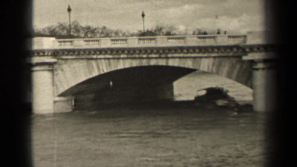 1947 Paris frame of a boat passing beneath a balustraded stone bridge while small pedestrians move along the roadway above.
