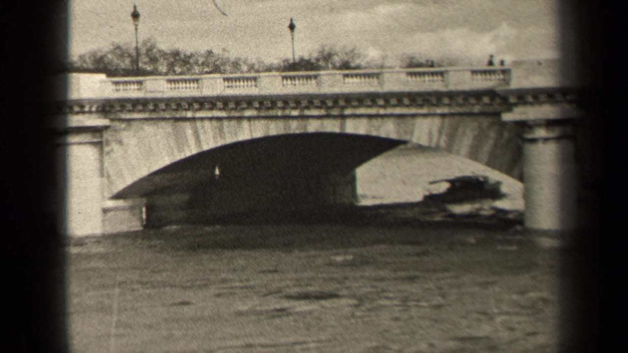 1947 Paris home-movie view of a small boat moving through the bridge shadow, with railings, lampposts, and pedestrians above.