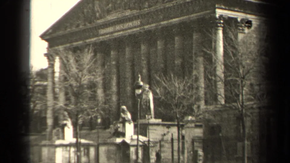 1947 Paris frame holding on a neoclassical public monument with columns, statues, bare trees, lamps, and an iron fence.