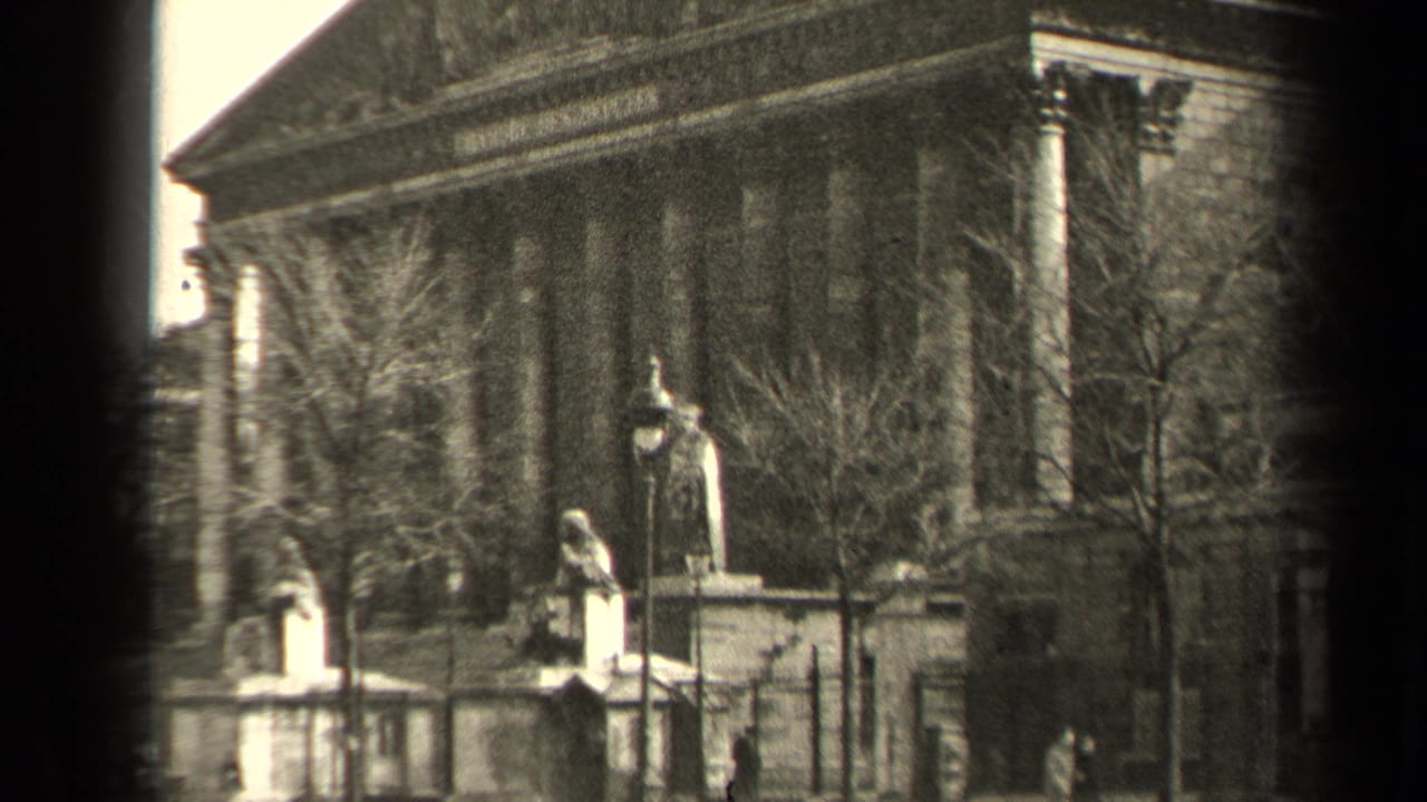 1947 Paris home-movie view of a neoclassical public building with statues, trees, and soft 8mm grain.