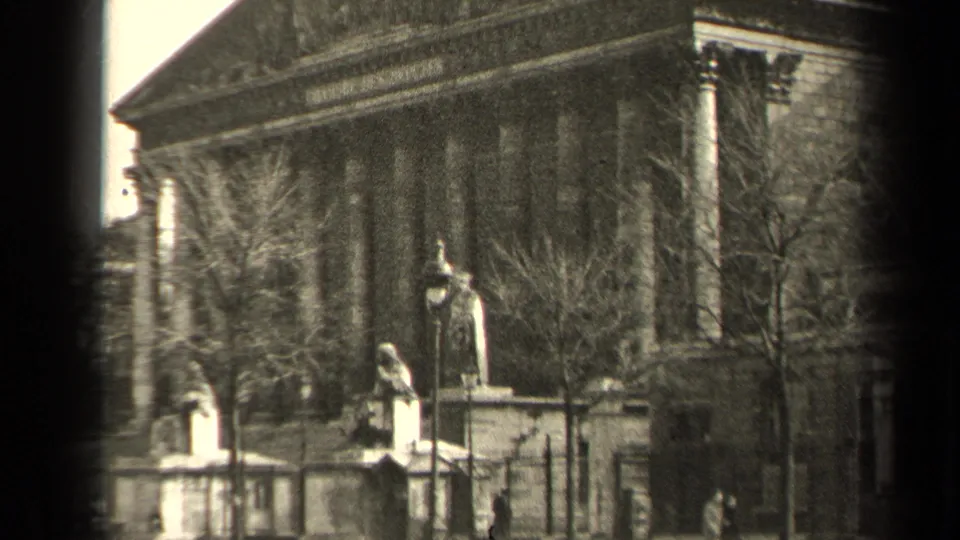 1947 Paris home-movie view of a neoclassical public building with statues, trees, and soft 8mm grain.