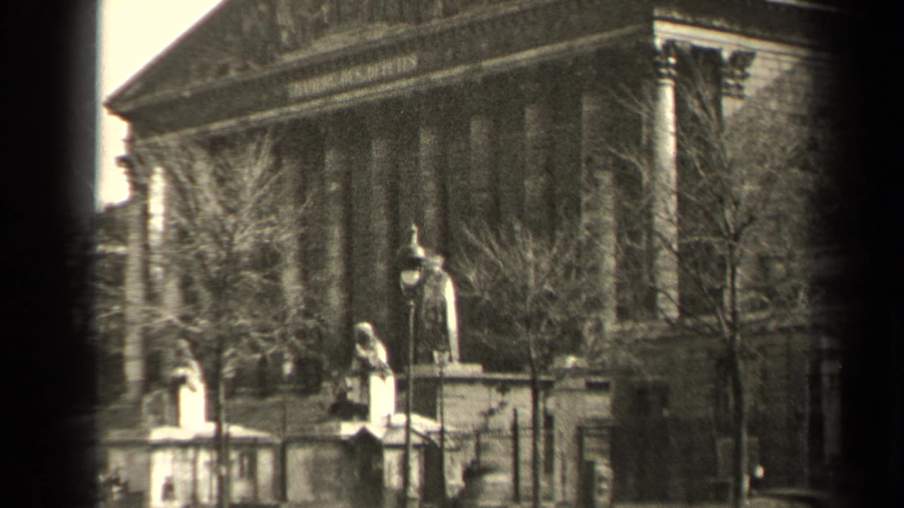 1947 Paris frame with foreground statues, a fenced approach, bare trees, and a neoclassical civic facade.