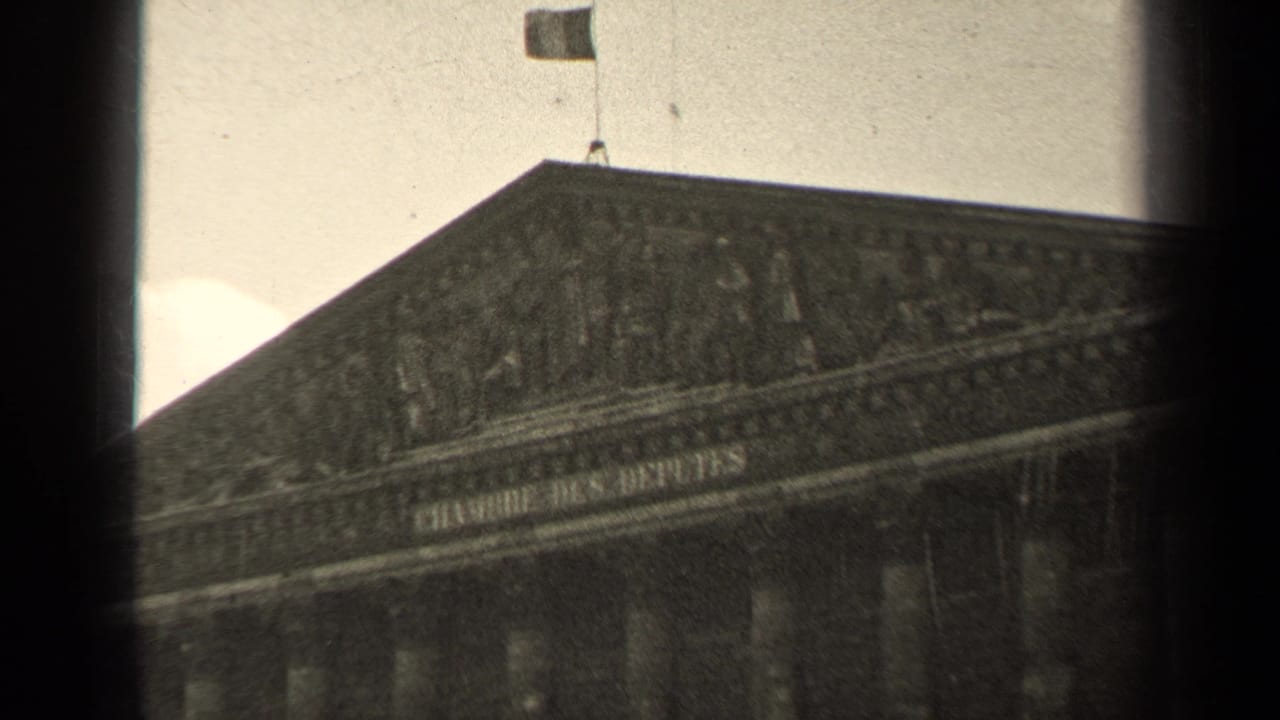 1947 Paris 8mm frame showing the Palais Bourbon pediment, upper facade, flag, and aged film texture.