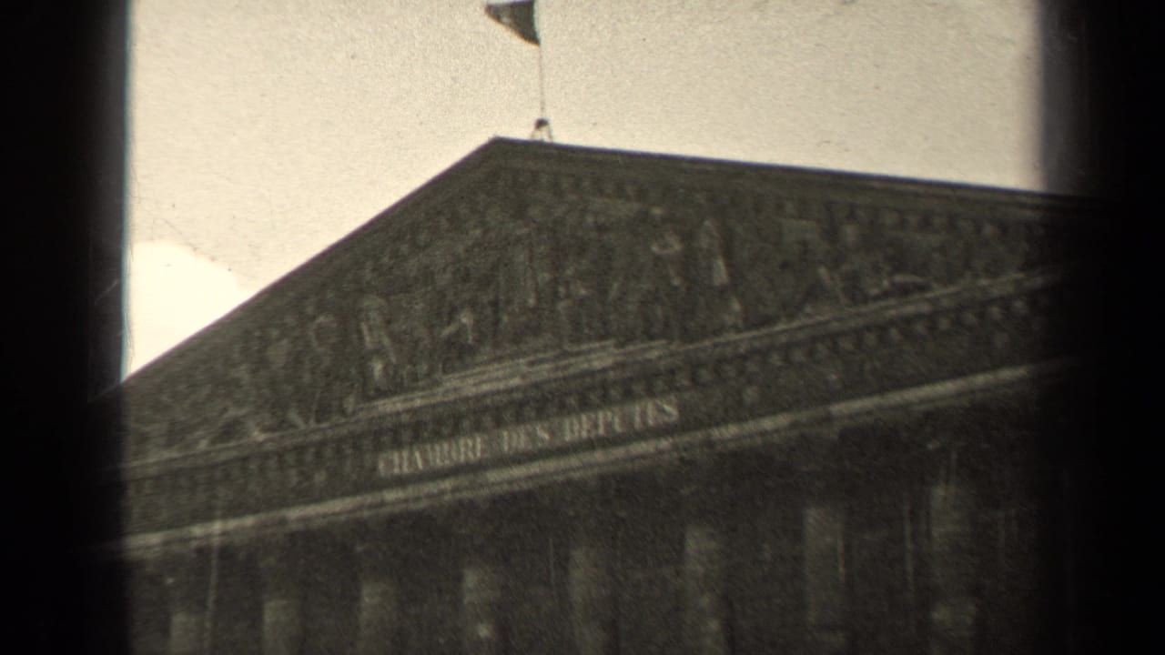 1947 8mm frame of the Chambre des Deputes facade in Paris, seen through dark film borders with columns and a flag visible.