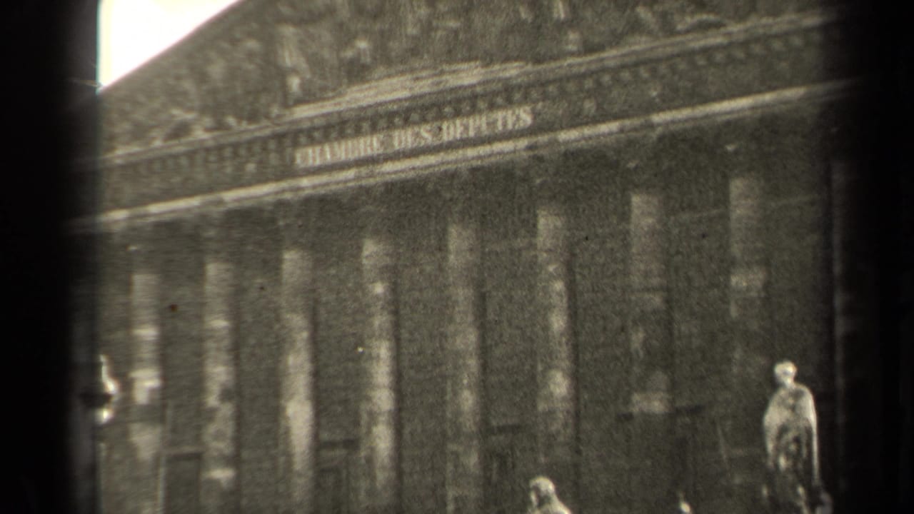 1947 Paris home-movie frame showing the Chambre des Deputes columns, base statues, steps, and a small distant pedestrian.
