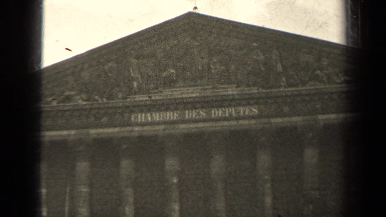 Blurred facade with triangular pediment and Chambre des Députés inscription.