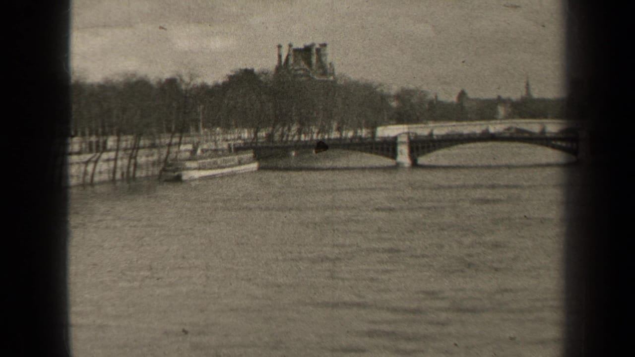 1947 Paris view along the Seine with an arched bridge, a riverboat near the bank, bare trees, and distant monuments.