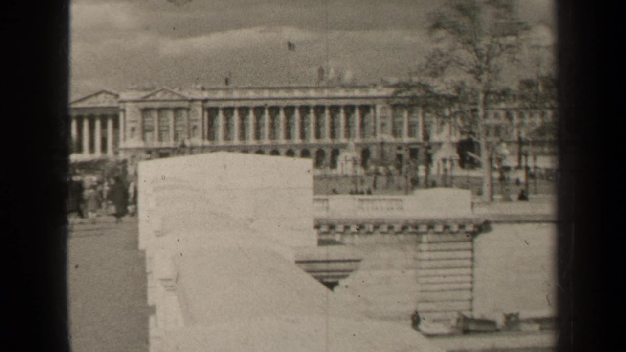 1947 Paris street view with a grand columned facade, low stone walls, trees, and small pedestrians in the distance.