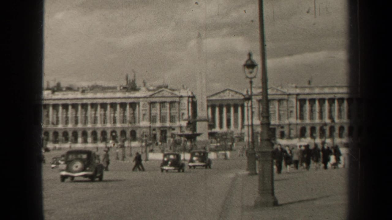 Paris, France in 1947, with mid-century cars, distant pedestrians, a streetlamp, obelisk base, and grand facades.