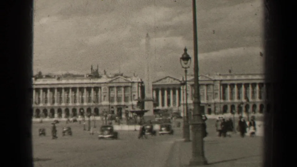 1947 Paris square view with traffic, walkers, lampposts, monumental buildings, and visible 8mm film borders.