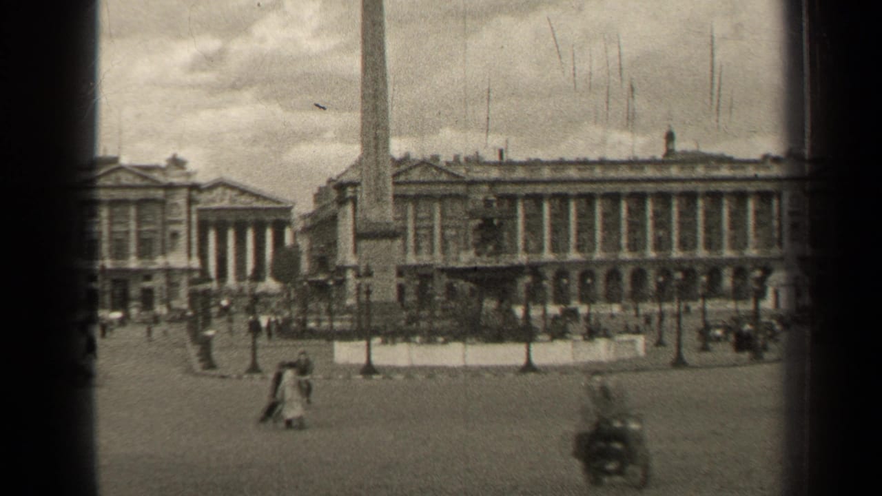 1947 Paris home-movie view of a broad public square with an obelisk, classical facades, pedestrians, and sparse vehicles.